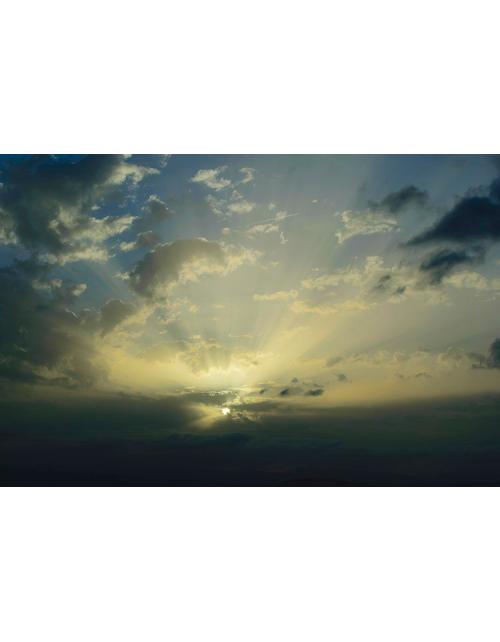 Fotografía de autor del amanecer en Bellus con rayos crepusculares proyectándose entre nubes